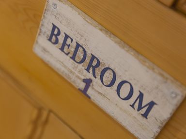 A wooden door with a sign reading bedroom 1 affixed to it at Chynance in Porthcurno