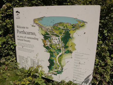 A map sign welcoming visitors to Porthcurno with information about the area and attractions in Porthcurno
