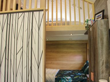 A bedroom with a lower bed with floral bedding and an upper bed with beige bedding at Jacob's Meadow Pod 2 Minsterley near Chirbury
