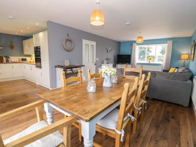 A dining room with a table and chairs at Cae Berllan Mynytho near Pwllheli