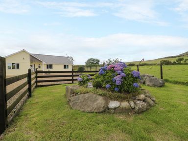A house with a garden and flowers at Cae Berllan near Pwllheli