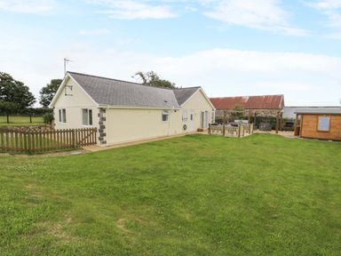 A house with a garden and fence at Cae Berllan in Mynytho near Pwllheli