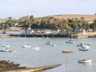 A harbor with sailboats on water and houses with trees in the background at Widgeons Keel in Flushing