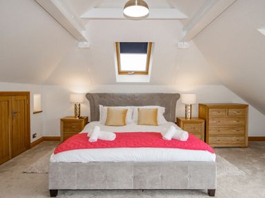 A bedroom with a bed and two bedside tables with lamps and a chest of drawers at Family House in Weymouth