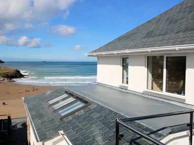 A view of a beach and ocean from the roof of a building at The White House in Polzeath