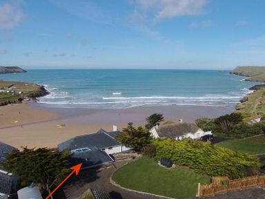 A coastal view with houses near a sandy beach and the sea at The White House in Polzeath