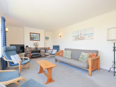 A living room with seating and television at Zapadiah in Polzeath