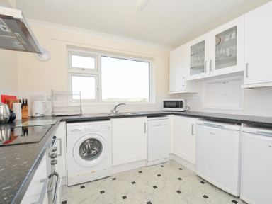 A kitchen with a washing machine and microwave at Zapadiah in Polzeath
