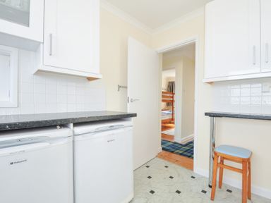 A kitchen with a dishwasher and a door leading to another room at Zapadiah in Polzeath