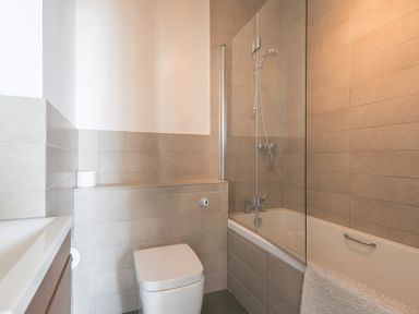 A bathroom with a toilet a bathtub with shower and a sink at 4 The Terrace in Rock