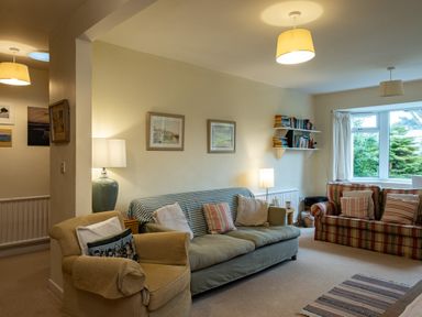 A living room with sofas cushions lamps bookshelves and framed pictures at Pencreek in Rock