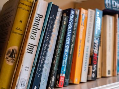 A close up of a bookshelf with books stacked at Pencreek in Rock
