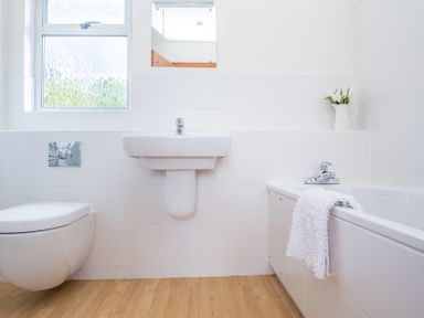 A bathroom with a toilet sink bathtub mirror and a window at Rosevallen in Daymer Bay