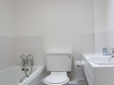 A bathroom with a bathtub, a toilet, and a sink with a faucet at Slipway 10 in Rock