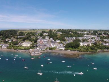 A coastal village with boats in the water and houses along the shoreline at Slipway 10 in Rock