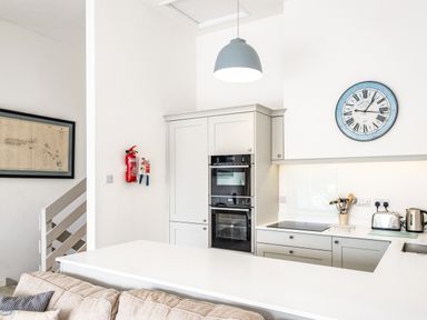 A kitchen with built in ovens a stove a blue clock and a fire extinguisher at Slipway 10 Rock