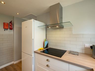 A kitchen with a refrigerator induction stove hood and knives at Slipway 15 in Rock