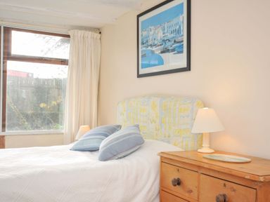 A bedroom with a bed, pillows, lamp, and picture at Avoca in Rock