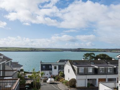 A view of houses near a body of water with green hills in the distance at Slipway 19 in Rock
