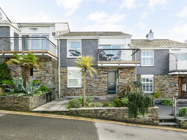 A stone and slate house with balconies and plants in front at Slipway 21 in Rock