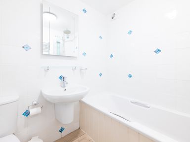 A bathroom with a toilet sink bathtub and a mirror with showerhead reflected at Slipway 21 in Rock