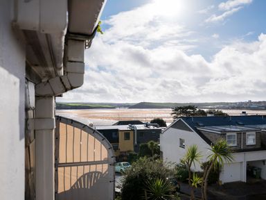 View of rooftops and beach with sand and water under a cloudy sky at Slipway 21 in Rock