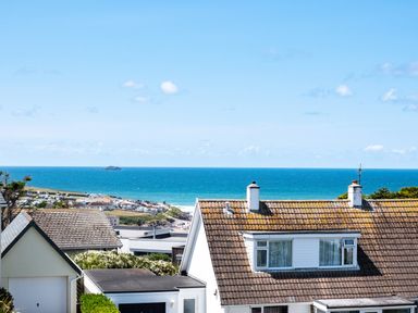 A coastal view with houses in the foreground and the ocean in the background at Little Belz in Polzeath