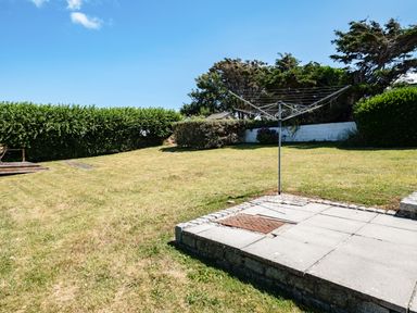 A backyard with a rotary clothesline and trimmed grass at Little Belz in Polzeath