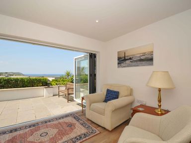 A living room with chairs and a view at Sunset in Polzeath
