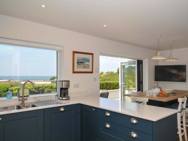 A kitchen with a sink and coffee maker at Sunset in Polzeath