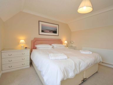 A bedroom with a bed and bedside tables at Sunset in Polzeath