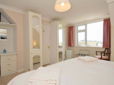 A bedroom with a double bed and wardrobe at Sunset in Polzeath