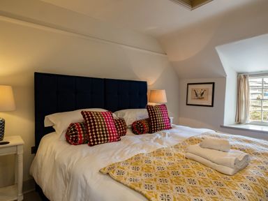 A bedroom with a double bed lamps on side tables and a window at Porthilly Greys in Rock