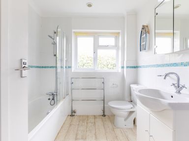 A bathroom with a bathtub shower toilet sink and window at Trebartha in Daymer Bay