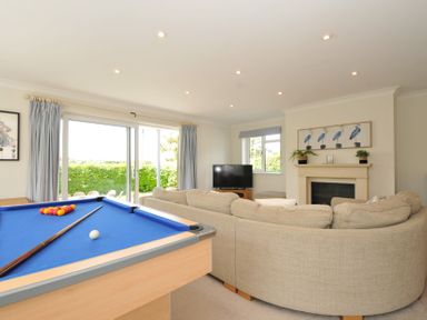A living room with a pool table and sofa at Farlands in Daymer Bay
