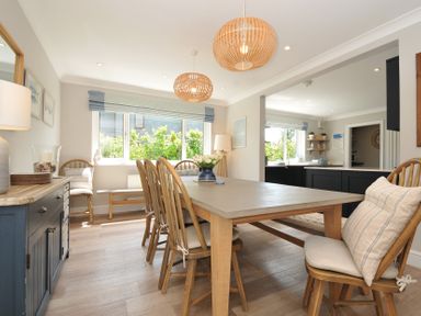 A dining room with a table and chairs at Farlands in Daymer Bay