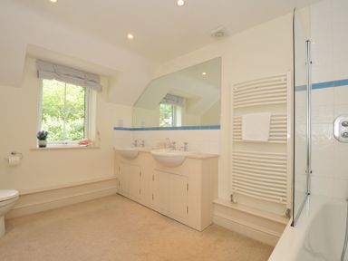 A bathroom with two sinks and a bathtub at Farlands in Daymer Bay