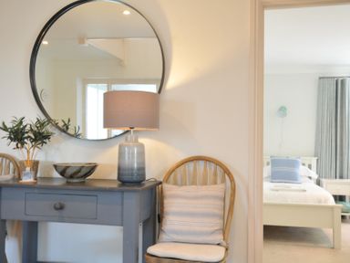 A bedroom with a console table and lamp at Farlands in Daymer Bay