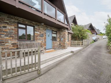 An outdoor view of a house with a blue door and a wooden bench at Rocklings in Rock