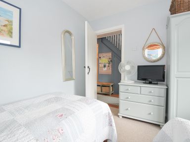 A bedroom with a bed, mirror, fan, and television at Rocklings, Rock