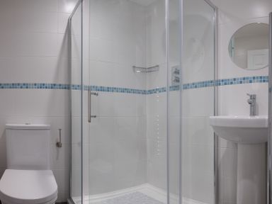 A bathroom with a shower enclosure toilet and a pedestal sink at Cogenhoe in Rock