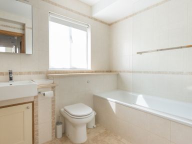 A bathroom with a toilet sink mirror window and bathtub at Ragleighs in Daymer Bay
