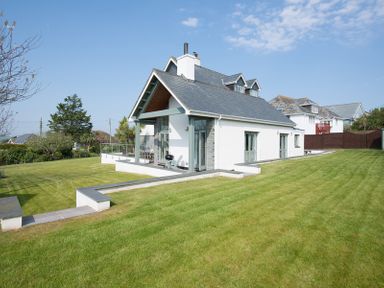 A house with a large lawn and patio area at Ragleighs in Daymer Bay
