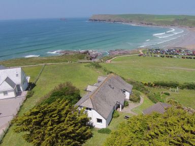 A coastal landscape with houses near the ocean and a beach at Gullsway Sandpiper in Polzeath