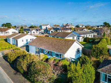 A neighborhood with single-story houses and hedges under a clear sky at Little Sailing in Rock