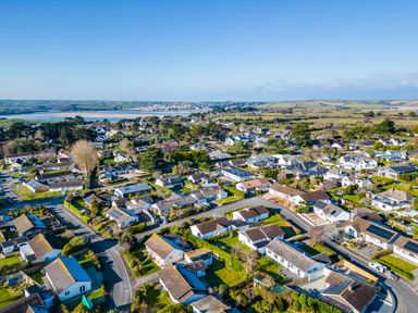 Aerial view of a residential neighborhood with houses and roads surrounded by green fields at Little Sailing in Rock