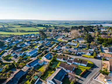 An aerial view of a residential neighborhood with houses roads and green fields in the background at Little Sailing in Rock