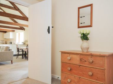 A chest of drawers with a vase and flowers in a living room at Mill Pond in Rock