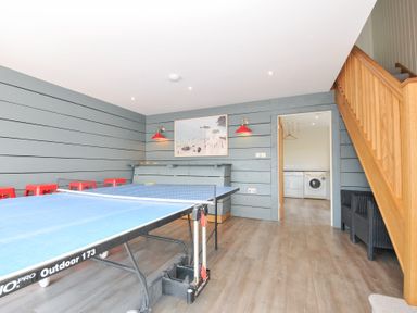 A games room with a ping pong table and red stools at Porthilly Brook in Rock