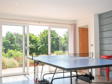 A game room with a ping pong table and sliding doors at Porthilly Brook in Rock